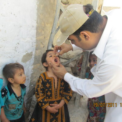 Doctor gives oral polio vaccine to unvaccinated children in Union Council Kharootabad, Pakistan, during the polio campaign, July 2011.