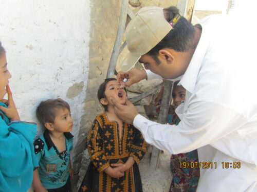 Doctor gives oral polio vaccine to unvaccinated children in Union Council Kharootabad, Pakistan, during the polio campaign, July 2011.