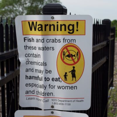 Warning sign advising people that fish and crabs from the nearby waters contain chemicaals and may be harmful to eat. Taken on the Riverdale Promenade in the Riverdale neighborhood of the Bronx.