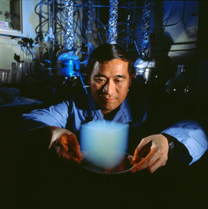 A scientists holds a cube of glowing blue material