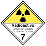 A diamond-shaped warning sign with a yellow top displaying a black radiation symbol. Text reads Radioactivo with Contiene...Uranio and Actividad...Activo below. The number 7 is at the bottom.